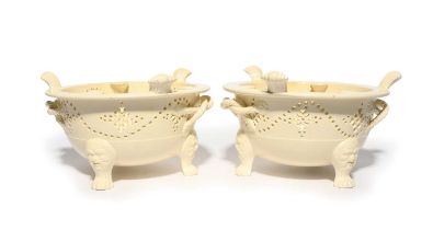 A pair of Leeds creamware punch kettle stands, c.1780, the circular forms raised on three paw feet