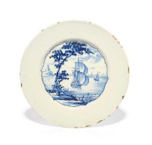 A rare Bristol delftware plate, c.1740, the well painted in blue with a shaped panel of ships at