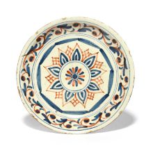 A London delftware dish or shallow bowl, c.1720-30, painted in red and blue with a central simple