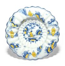 A large Delft lobed dish, c.1700, painted in blue and yellow with a Chinese figure kneeling in a