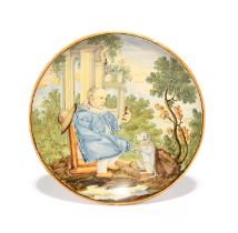 A Castelli maiolica saucer, mid 18th century, painted with a seated figure wearing a ruff and a blue