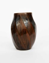 Φ Chris Carter (born 1945) a stoneware vase, twisted, swollen form, covered in a tenmoku glaze