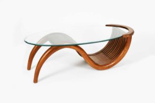 A teak and glass Wave coffee table probably Danish, the curved base, with pierced slat sections,