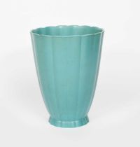 A Wedgwood pottery vase designed by Keith Murray, footed form, the flaring fluted body glazed matt