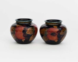 'Pomegranate' a pair of Moorcroft Pottery vases designed by William Moorcroft, shouldered, ovoid