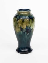 'Leaf and Berry' a Moorcroft Pottery vase designed by William Moorcroft, slender, baluster form,