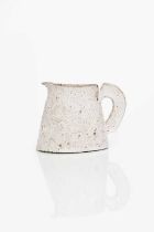 Φ Emmanuel Cooper OBE (1938-2012) a stoneware jug, covered in a pitted white glaze with pale pink,