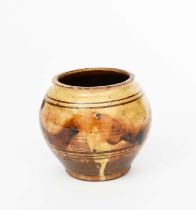 Michael Cardew CBE (1901-1983) an ovoid pottery vase, glazed to the foot with a sand yellow glaze,