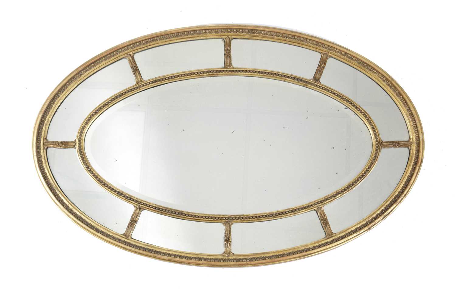 AN OVAL GILTWOOD AND GESSO MIRROR IN GEORGE III ADAM STYLE, LATE 19TH / EARLY 20TH CENTURY the