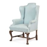 A WALNUT WING ARMCHAIR IN GEORGE II STYLE, LATE 19TH CENTURY on cabriole front legs united by turned