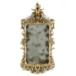 A GEORGE III GILTWOOD MIRROR C.1770 the shaped rectangular plate inside a scrolling foliate,