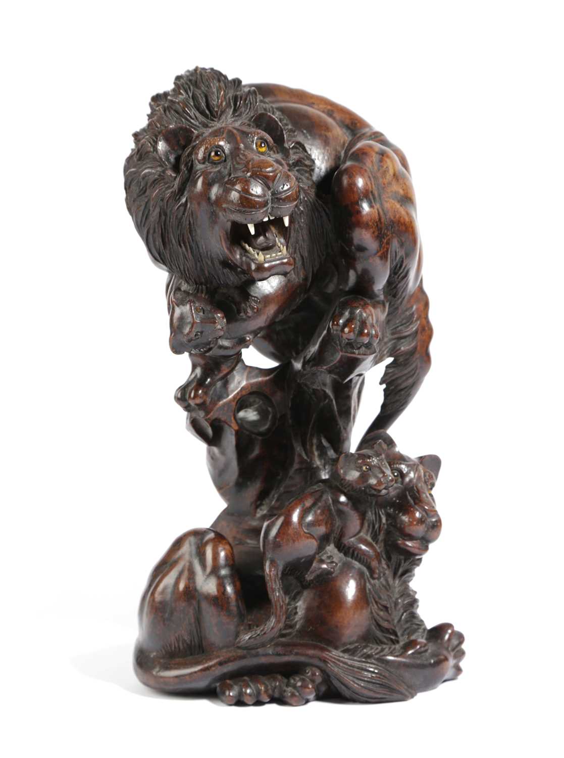 A JAPANESE HARDWOOD LION GROUP LATE 19TH CENTURY carved as a male lion and cub perched on a rock