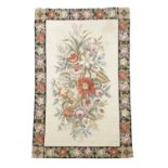 A CHINESE NEEDLEPOINT RUG LATE 20TH CENTURY the cream field with a polychrome floral spray