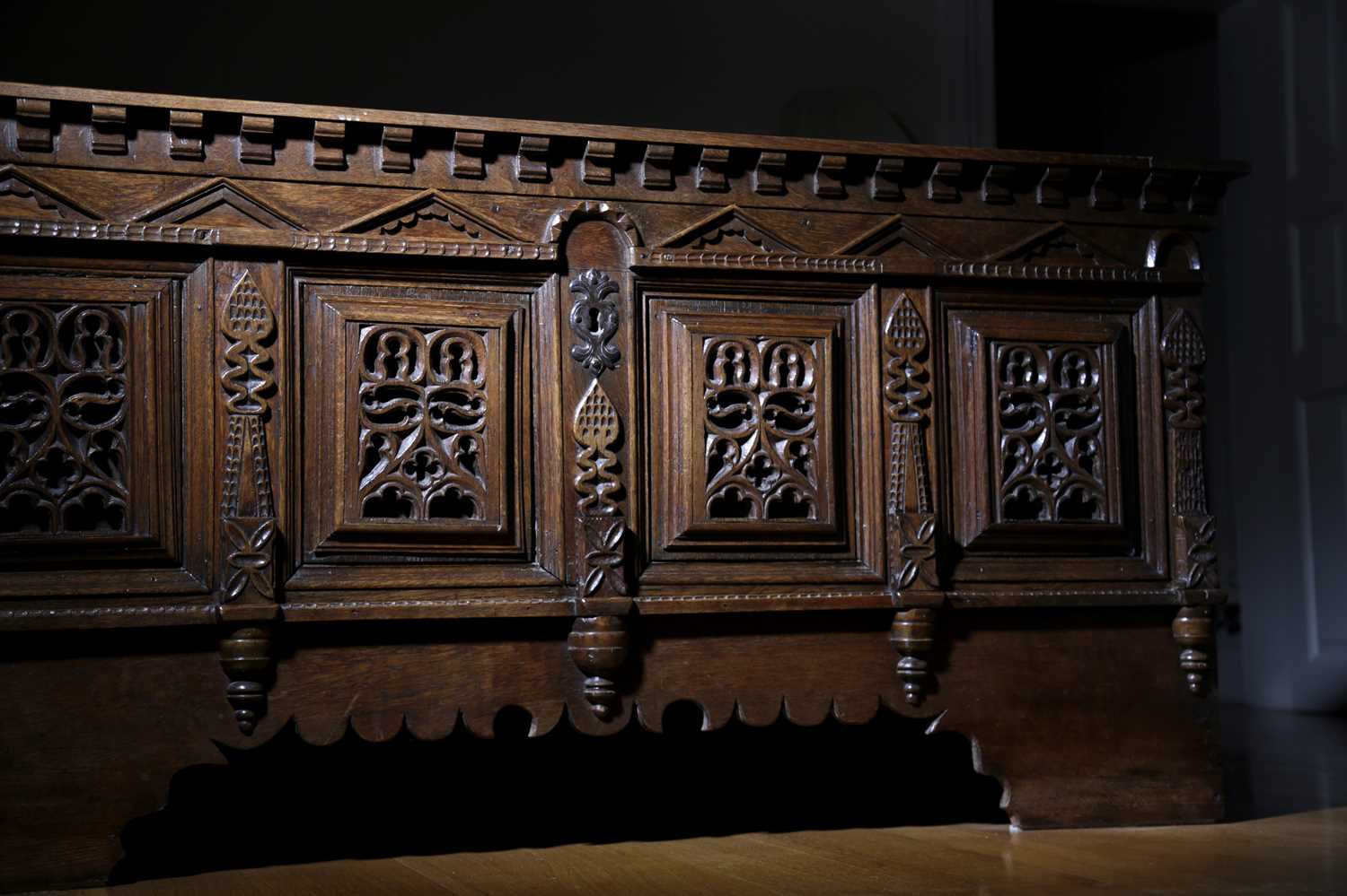 A RARE OAK COFFER POSSIBLY FLEMISH, C.1640 the twin panelled top with scrolling iron strap hinges,