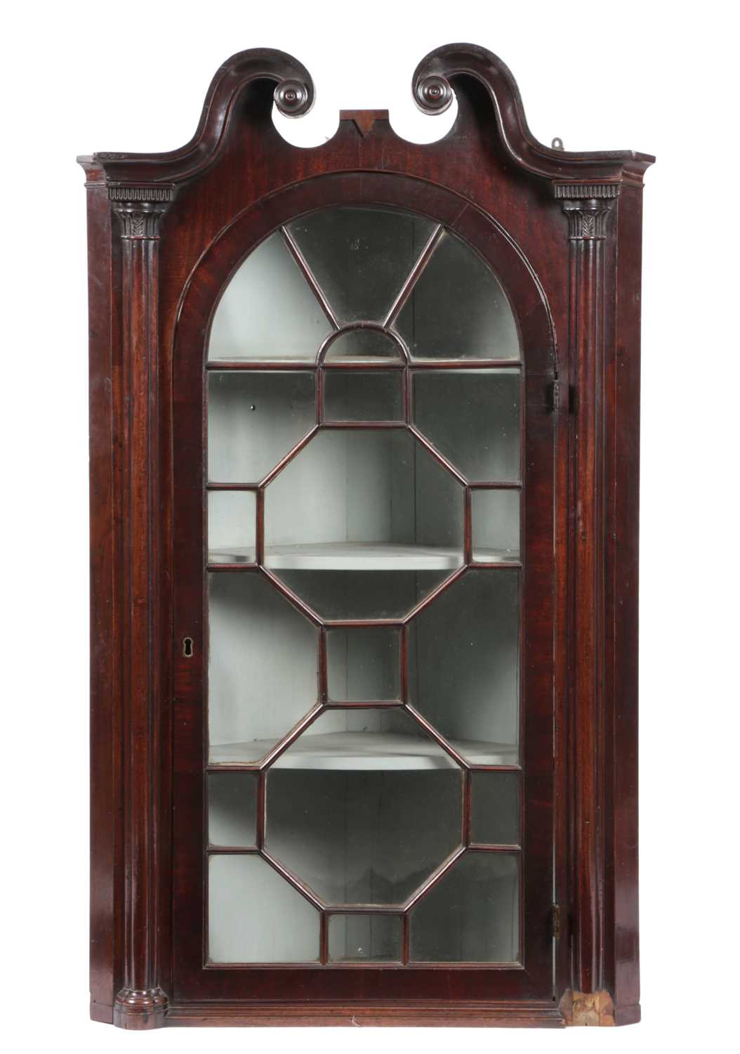 A GEORGE III MAHOGANY HANGING CORNER CUPBOARD C.1770 of architectural form, the swan neck cornice