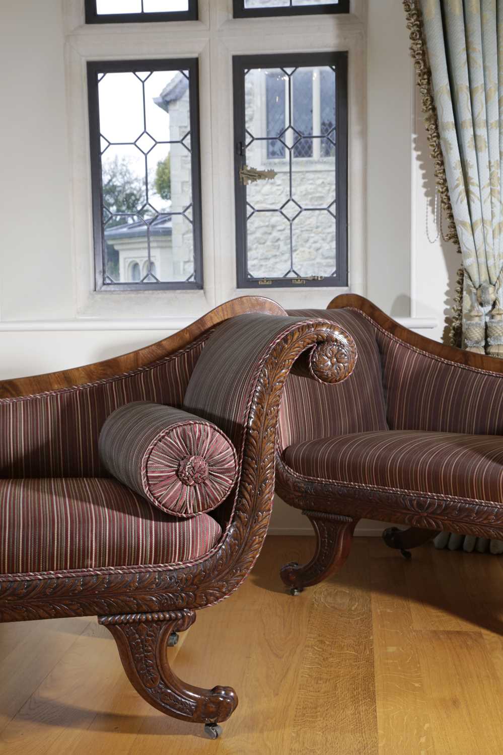 A PAIR OF REGENCY MAHOGANY SOFAS C.1820 the asymetrical scrolling arms with stuffed-over upholstery,