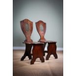 A PAIR OF GEORGE III MAHOGANY NEO-CLASSICAL HALL CHAIRS C.1770 each with a shield shape back with