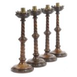 A SET OF FOUR VICTORIAN OAK GOTHIC REVIVAL CANDLESTICKS LATE 19TH CENTURY each with a brass