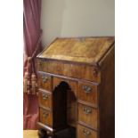 A QUEEN ANNE WALNUT KNEEHOLE BUREAU C.1710 the fall front with feather banding and enclosing a