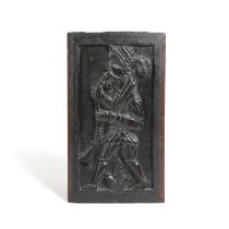 A TUDOR CARVED OAK PANEL EARLY / MID-16TH CENTURY depicting a bearded man playing a woodwind
