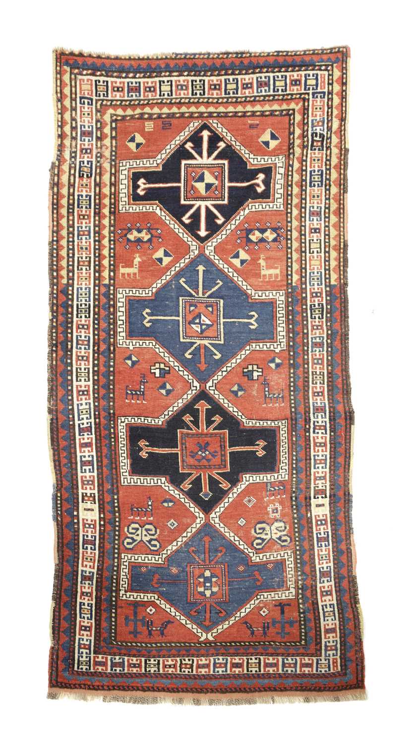 A KAZAK RUG CENTRAL CAUCASUS, C.1890 the madder field with four linked panels of hooked motifs