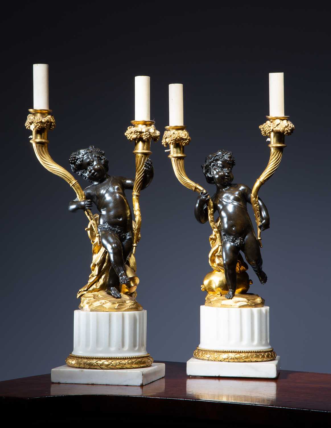 A PAIR OF FRENCH LOUIS XVI GILT AND PATINATED BRONZE CANDELABRA AFTER CLAUDE MICHEL, KNOWN AS
