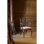A QUEEN ANNE WALNUT ARMCHAIR C.1710 the shaped rectangular back with a vase splat above scrolling