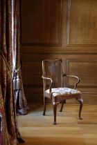 A QUEEN ANNE WALNUT ARMCHAIR C.1710 the shaped rectangular back with a vase splat above scrolling