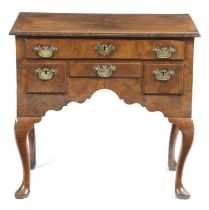 A QUEEN ANNE WALNUT LOWBOY C.1710 cross and feather banded, the quarter veneered top above one