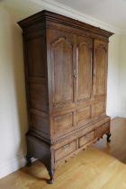 A GEORGE II OAK LIVERY CUPBOARD ON STAND SHROPSHIRE, C.1740 with cherrywood banding and inlaid