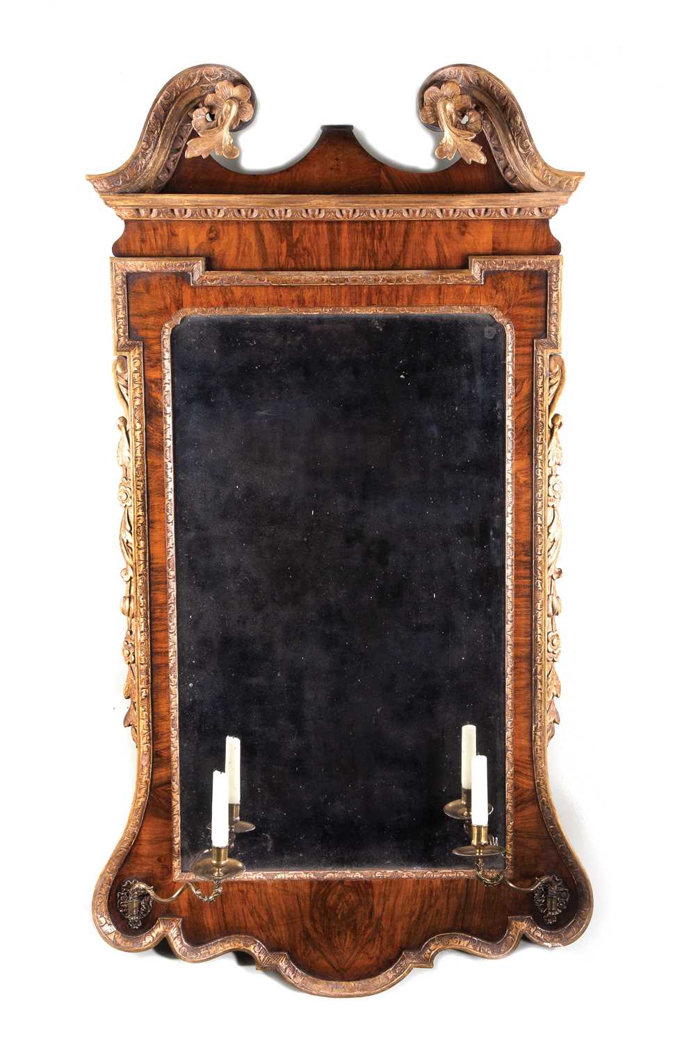 A GEORGE II WALNUT AND GILTWOOD MIRROR C.1735 the bevelled plate within a carved slip and walnut