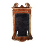 A GEORGE II WALNUT AND GILTWOOD MIRROR C.1735 the bevelled plate within a carved slip and walnut