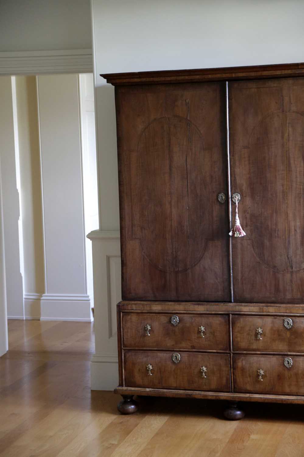 A QUEEN ANNE WALNUT ESTATE CUPBOARD C.1710 the moulded cornice above a pair of doors with oval