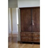 A QUEEN ANNE WALNUT ESTATE CUPBOARD C.1710 the moulded cornice above a pair of doors with oval