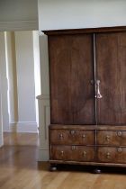 A QUEEN ANNE WALNUT ESTATE CUPBOARD C.1710 the moulded cornice above a pair of doors with oval