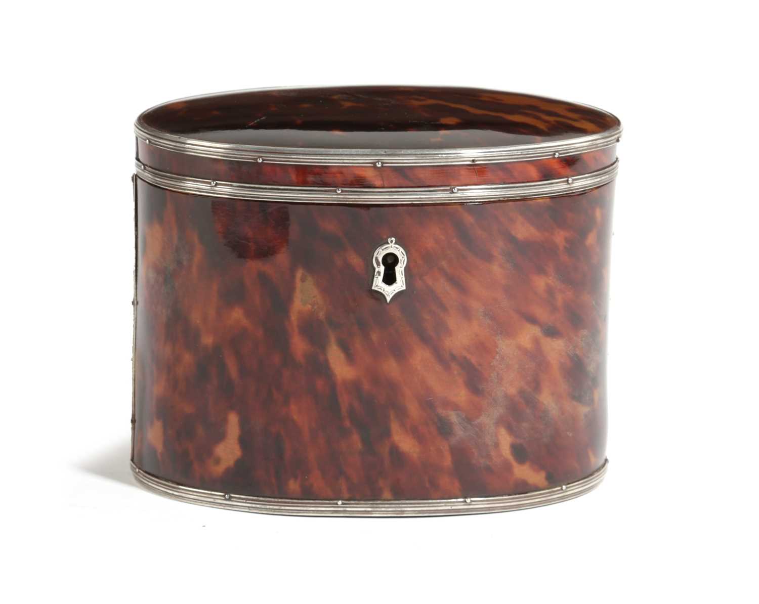 λ A GEORGE III TORTOISESHELL OVAL TEA CADDY LATE 18TH CENTURY with silver mounts and escutcheon, the