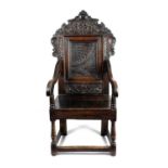 A CHARLES II OAK ARMCHAIR POSSIBLY WELSH, C.1660 the cresting carved with foliate strapwork below