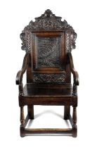 A CHARLES II OAK ARMCHAIR POSSIBLY WELSH, C.1660 the cresting carved with foliate strapwork below