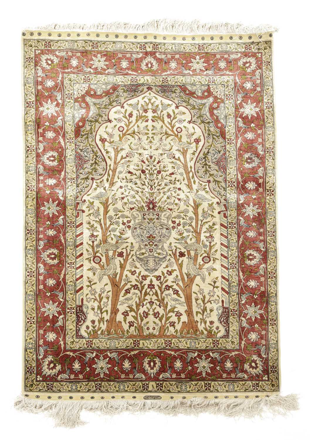 A HEREKE SILK PRAYER RUG NORTH WEST ANATOLIA, C.1970 the cream field with an urn issuing flowers