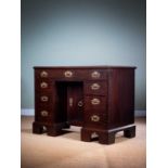 A GEORGE II MAHOGANY KNEEHOLE DESK MID-18TH CENTURY the caddy moulded edge top above an