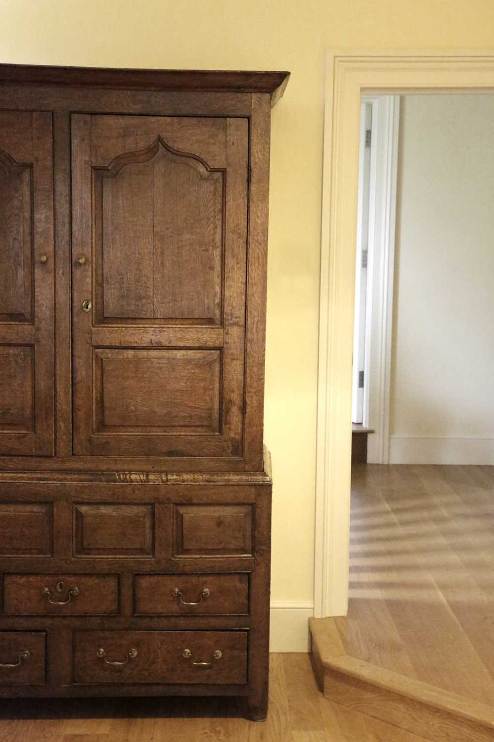 A GEORGE III OAK LIVERY CUPBOARD c.1760-70 with a pair of doors with Gothic ogee panels enclosing an