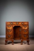 A FINE GEORGE II WALNUT KNEEHOLE DESK / DRESSING TABLE C.1730 with feather and cross banding, the