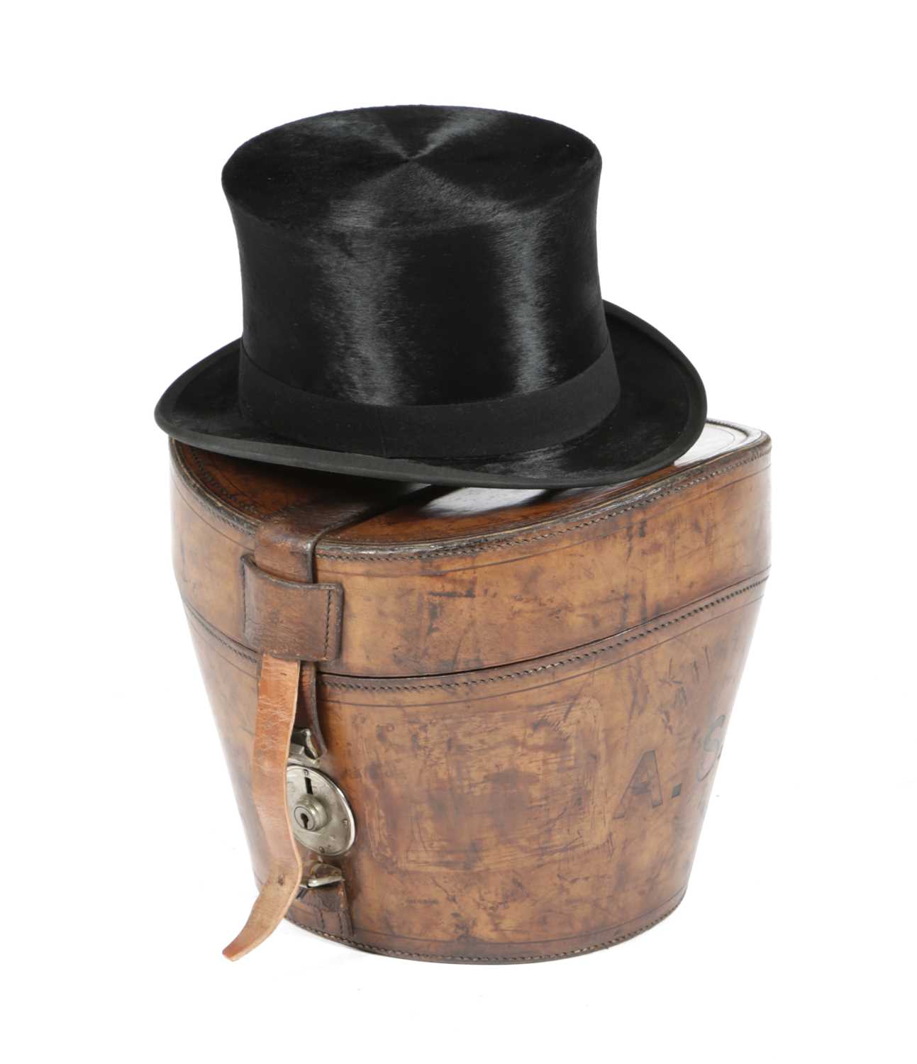 A BROWN LEATHER HAT BOX AND SILK TOP HAT LATE 19TH / EARLY 20TH CENTURY with a quilted interior, the