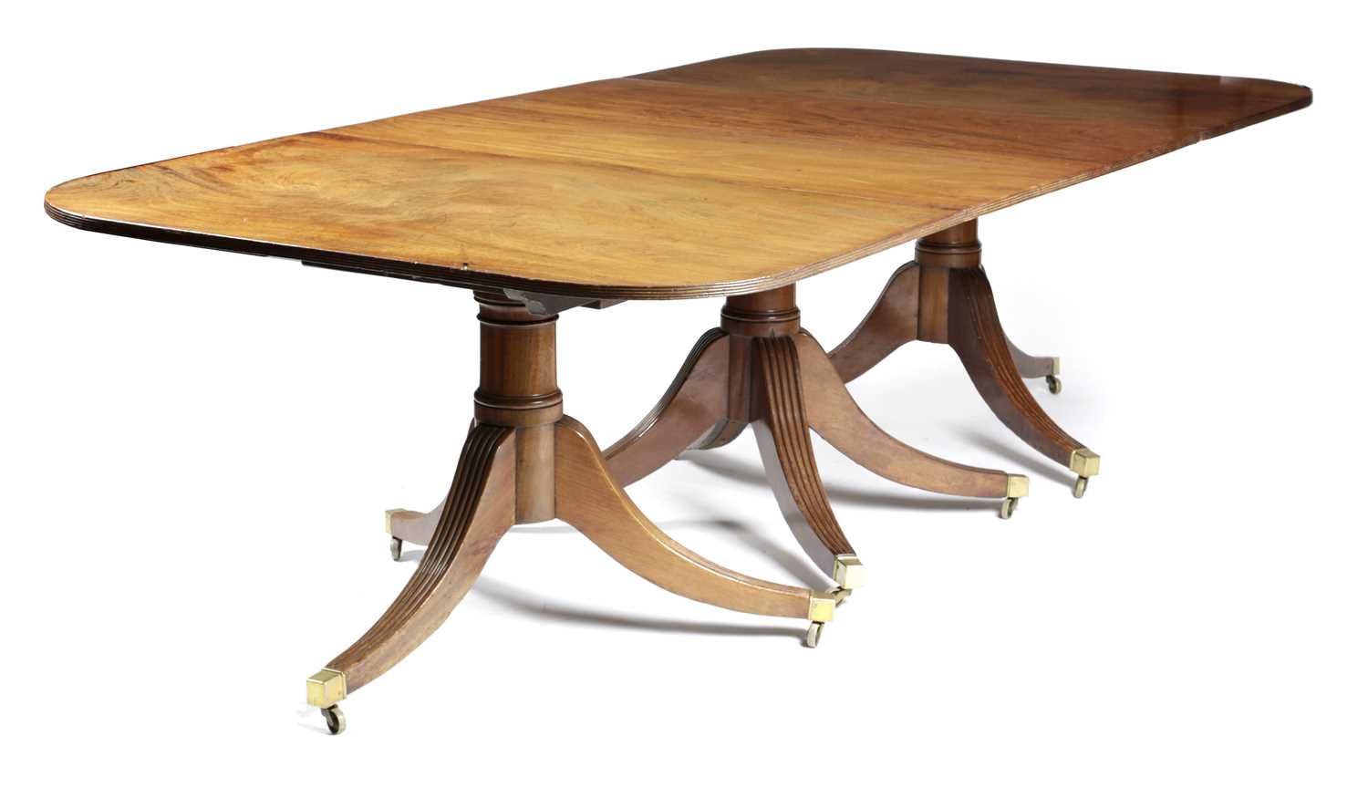 A GEORGE IV MAHOGANY TRIPLE PILLAR DINING TABLE C.1825 AND LATER the reeded edged top above turned