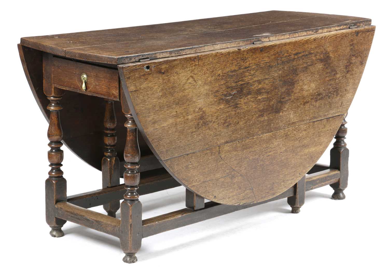 AN OAK OVAL GATELEG DINING TABLE EARLY 18TH CENTURY AND LATER with a single drawer on block and