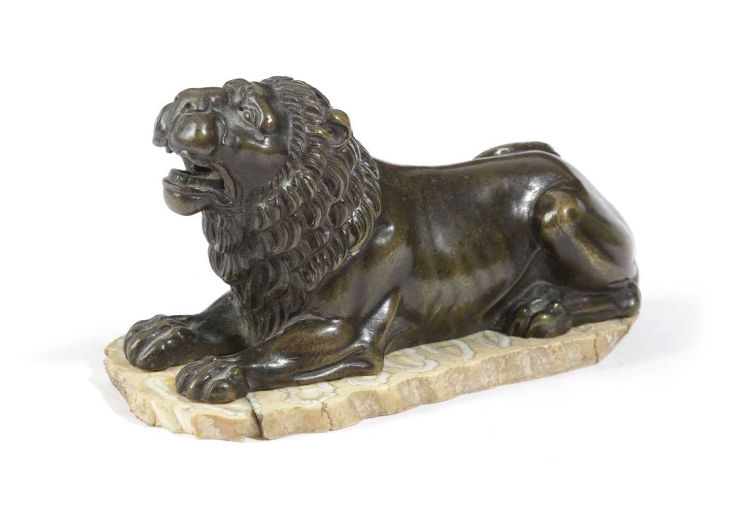 A FRENCH BRONZE MODEL OF A RECUMBENT LION EARLY 19TH CENTURY later mounted on a slice of mammoth