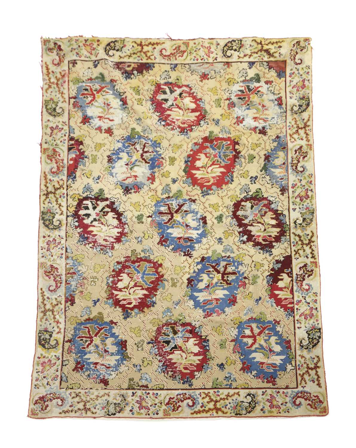 A EUROPEAN NEEDLEPOINT RUG C.1900 the pale wheat field with polychrome rondels enclosed by floral