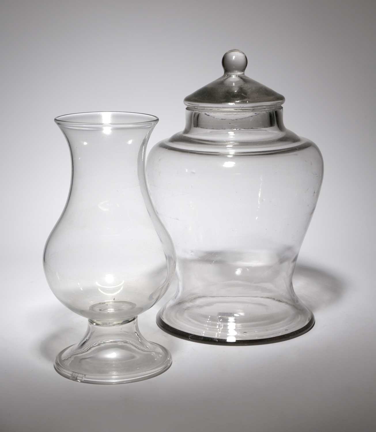 A GLASS STORAGE JAR AND COVER 19TH CENTURY of inverted baluster form, with a ball finial, together