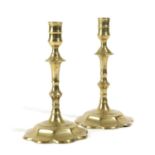 A PAIR OF GEORGE II BRASS CANDLESTICKS MID-18TH CENTURY each with a turned nozzle above a faceted