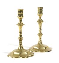 A PAIR OF GEORGE II BRASS CANDLESTICKS MID-18TH CENTURY each with a turned nozzle above a faceted